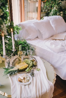 bed with sidetable that has champagin glasses