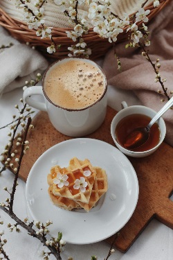 Plate with heart shaped waffles beside coffee